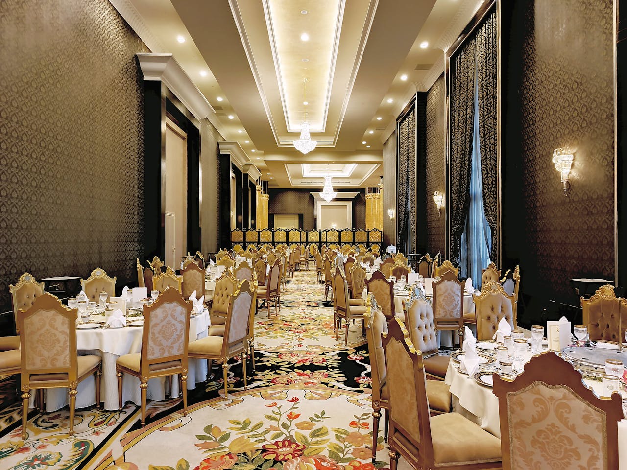 An opulent ballroom in a Kuala Lumpur hotel set up for a formal event with ornate decor.